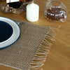 Seagrass placemat in natural color with woven texture and frayed edges made from natural fibers