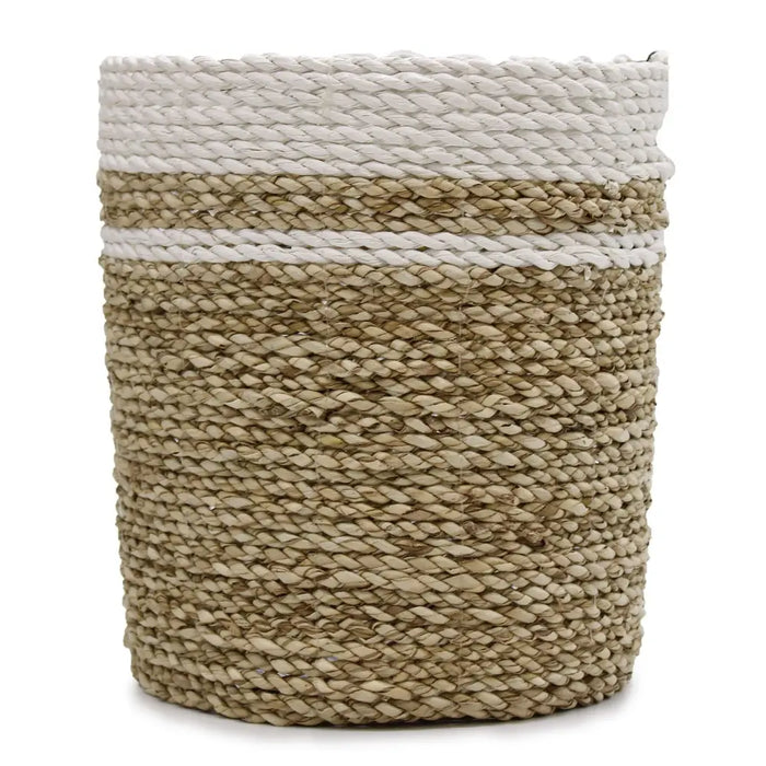 A beige cylindrical seagrass basket with two white rope bands shown as part of a set with vases and bins