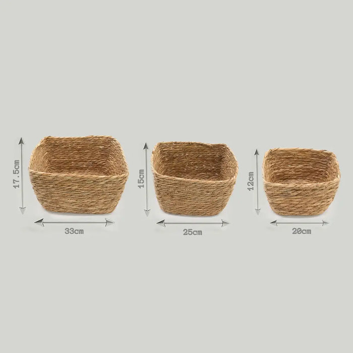 Three natural seagrass square baskets in varying sizes with a rustic woven texture for storage and organization