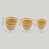 Set of three woven straw baskets in natural, yellow, and light green stripes made from seagrass and straw