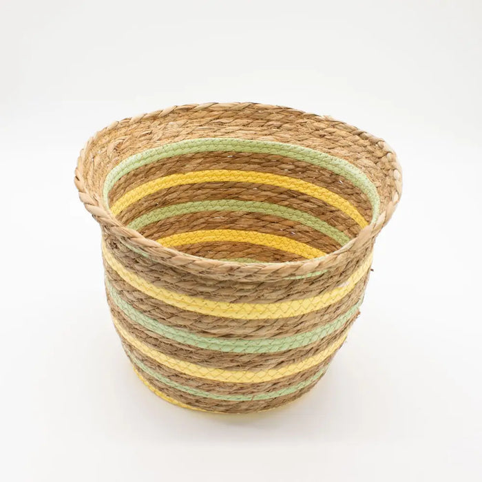 A woven set of three straw baskets with horizontal stripes in natural brown yellow and light green colors