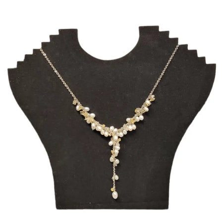 A gold-toned seed pearl and gemstone chip necklace with freshwater pearls and crystals on a black velvet bust