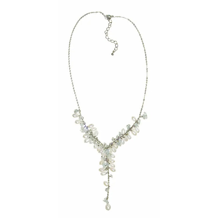 A delicate silver chain necklace with cascading white freshwater seed pearls and clear gemstone chip crystals in a v shape