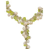 A seed pearl and gemstone chip necklace with white pearls and green peridot stones on a silver chain