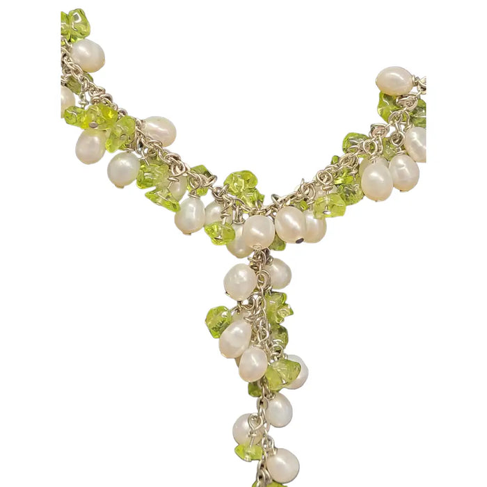 A seed pearl and gemstone chip necklace with white pearls and green peridot stones on a silver chain