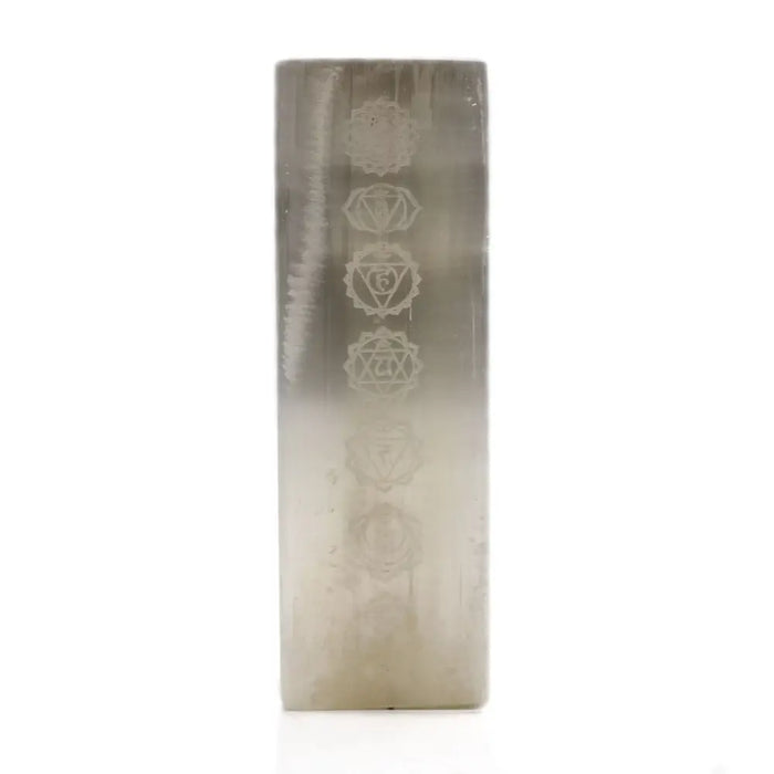 A translucent gradient silver selenite block lamp with etched chakra symbols running vertically on the crystal pillar