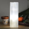 A translucent rectangular selenite block lamp with subtle engravings glowing softly for 7 chakra use