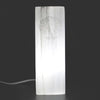 A translucent white selenite block lamp with a carved tree of life design made of natural selenite material