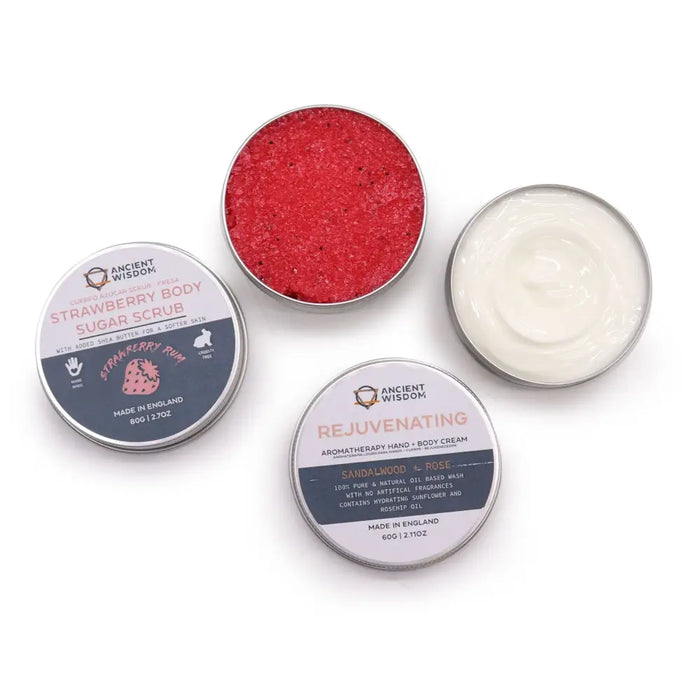 Two circular metal containers in the serenity essential care kit set includes red sugar scrub and creamy white body cream