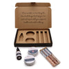 A brown cardboard serenity essential self care kit with a mindfulness message and wellness tins and tubes inside