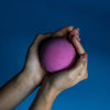 A vibrant purple spherical bath bomb with a textured powdery surface from a set of 3 cranberry bath bombs