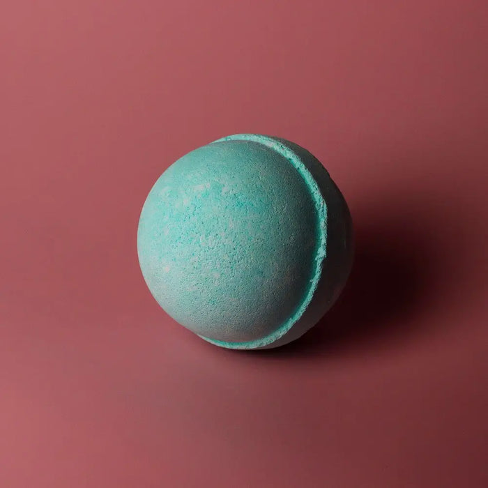 A round textured teal bath bomb with subtle color variation from a set of 3 bath bombs five for him