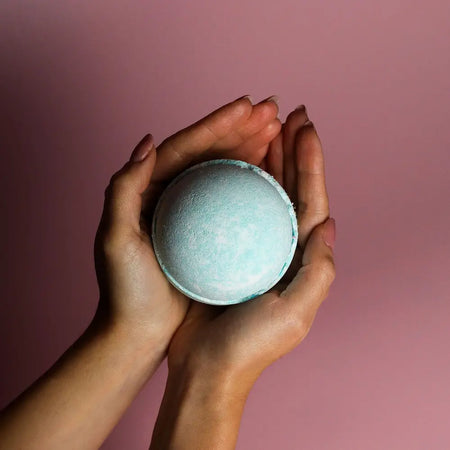 A soft pastel blue bath bomb with white marbling from the set of 3 bath bombs five for him collection