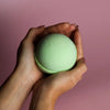 A soft mint green bath bomb with a textured surface from a set of 3 lemon eucalyptus bath bombs