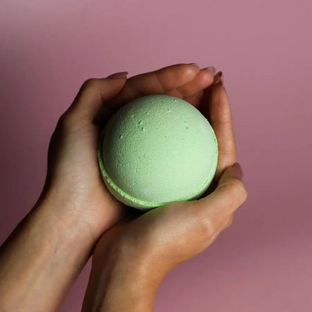 A soft mint green bath bomb with a textured surface from a set of 3 lemon eucalyptus bath bombs