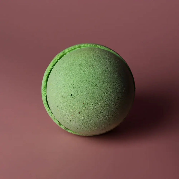 A round matte lime green bath bomb with a textured surface and ring detail from a set of 3 lemon eucalyptus bath bombs