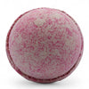 A round speckled pink and beige bath bomb with a textured surface from the party girl bath bombs set