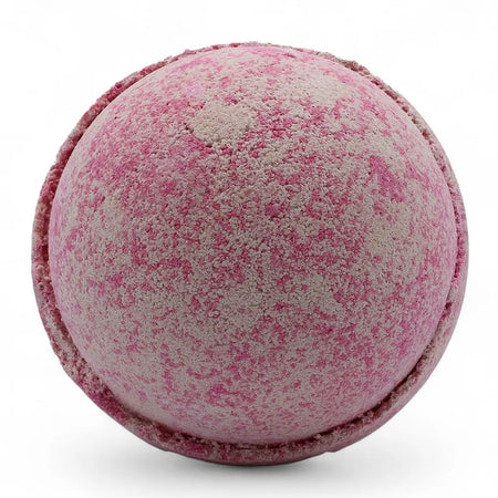A round speckled pink and beige bath bomb with a textured surface from the party girl bath bombs set