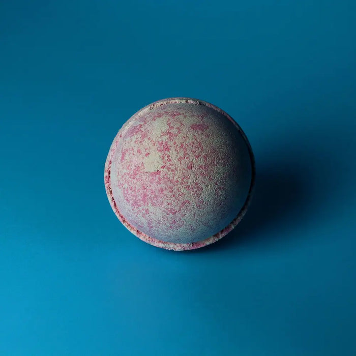 A spherical pink and white textured bath bomb from the party girl set of 3 bath bombs