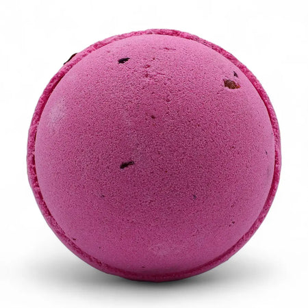 A vibrant magenta bath bomb with dark speckles in a set of 3 bath bombs featuring rose petals and texture