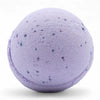 A lavender bath bomb with dark purple flecks from a set of 3 bath bombs scented with sweet fennel and jojoba