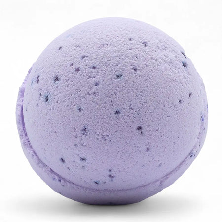 A lavender bath bomb with dark purple flecks from a set of 3 bath bombs scented with sweet fennel and jojoba