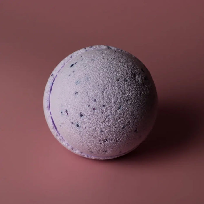 A lavender-colored bath bomb with speckled texture and subtle purple tones from a sweet fennel bath bombs set