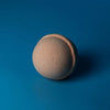 Beige spherical bath bomb with a textured surface and pinkish seam from set of 3 tangerine and grapefruit bath bombs