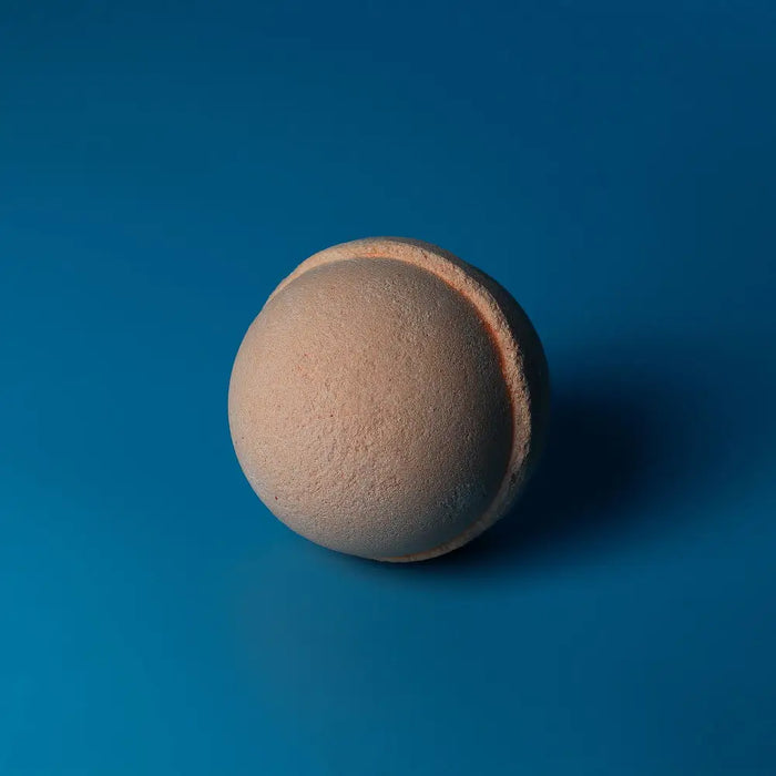 Beige spherical bath bomb with a textured surface and pinkish seam from set of 3 tangerine and grapefruit bath bombs