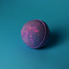 A spherical bath bomb with a textured surface in deep purple and pink hues from the yorkshire violet set of 3 bath bombs