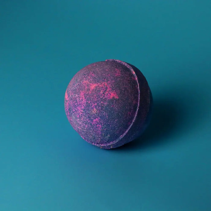 A spherical bath bomb with a textured surface in deep purple and pink hues from the yorkshire violet set of 3 bath bombs