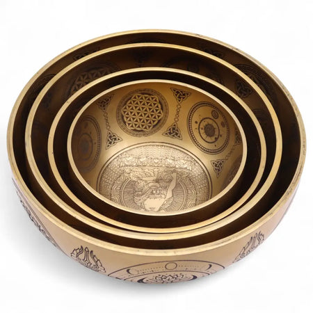 Set of five brass-colored etched singing bowls with intricate geometric and symbolic designs producing striking tone
