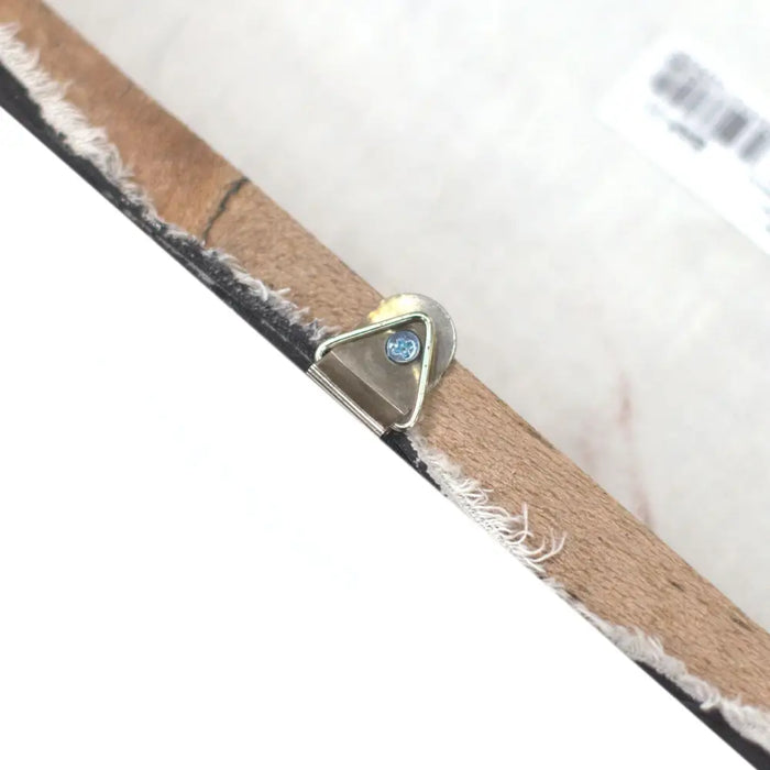A triangular metal hook with blue gemstone on the edge of a wooden canvas in set of 4 painted buddha heads sand finish