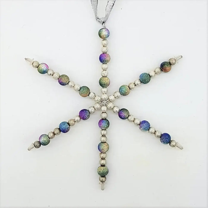 A silver snowflake hanging decoration with shimmering rainbow beads and silver beads on a metallic ribbon