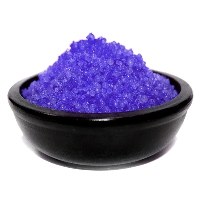 A black ceramic bowl holds vibrant purple blackberry simmering granules with a crystalline texture
