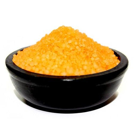 A sleek black ceramic bowl filled with vibrant orange coarse simmering granules cinnamon and orange flavor