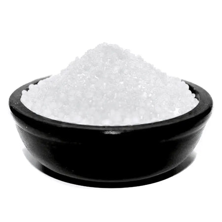 A black ceramic bowl filled with coarse white simmering granules for lily of the valley scent