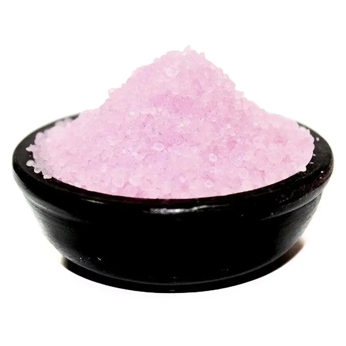 A mound of fine pink translucent salt crystals as simmering granules in a black ceramic bowl for vanilla musk use