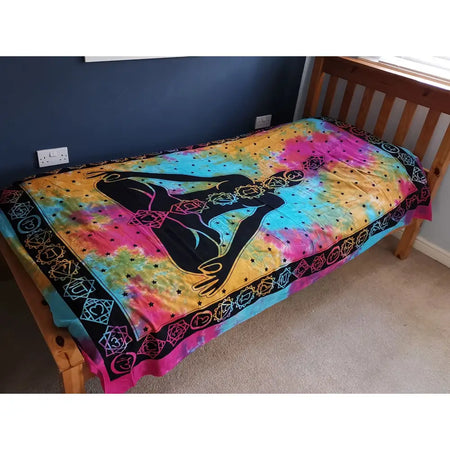 Vibrant pink and teal tie-dye single cotton bedspread with black meditating figure and chakra symbols with geometric border