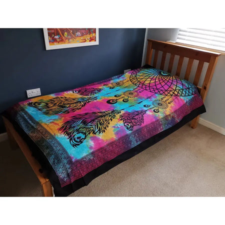 Single cotton bedspread with vibrant tie-dye rainbow colors featuring black feather dreamcatcher design as wall hanging