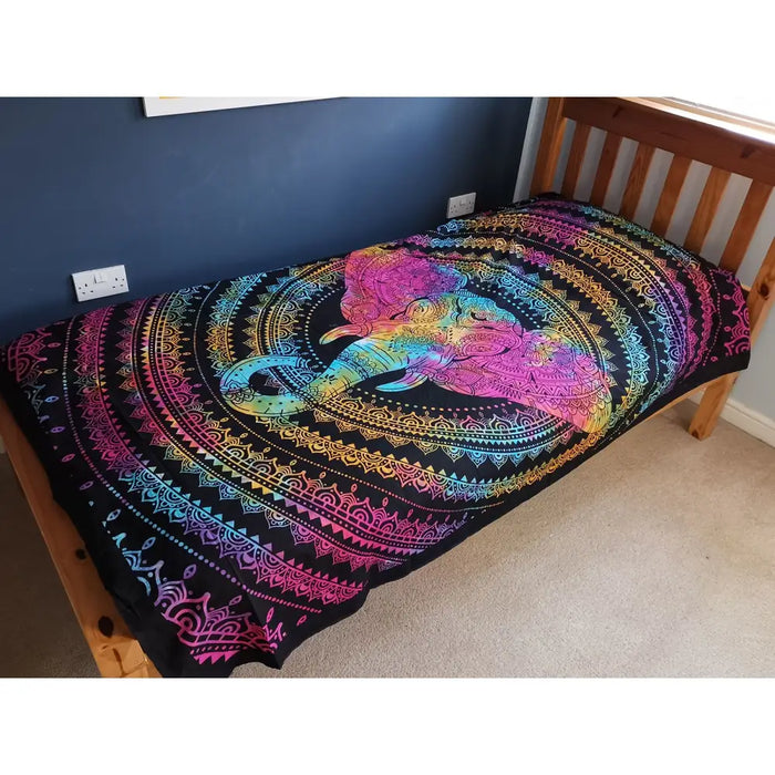 A vibrant rainbow-colored cotton bedspread wall hanging with an intricate elephant head mandala on black background