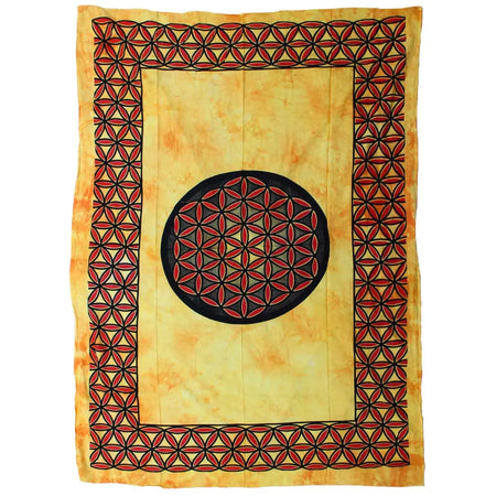 A cotton bedspread wall hanging with a black circle and red black flower of life pattern on an orange yellow tie dye background