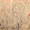 Single sheet handmade marbled gift wrap with swirling beige pink red and black patterns and green gold accents