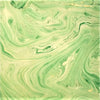 A single sheet handmade marbled gift wrap in green gold with a swirling cream marble pattern