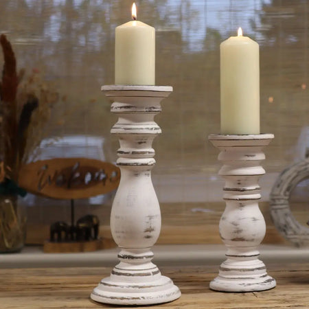 Small whitewashed mango wood candle stand with distressed finish holding cream-colored candles