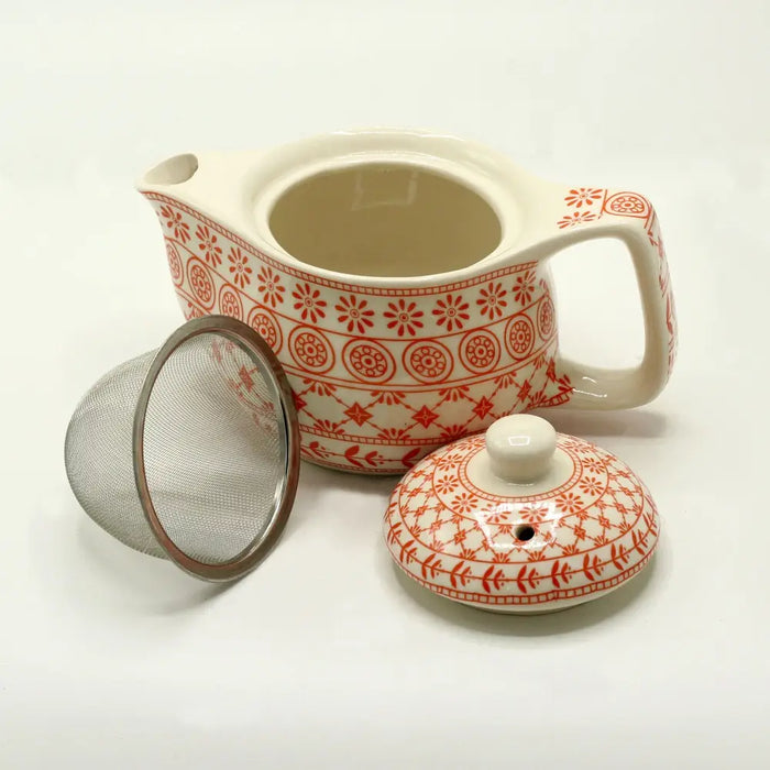 Cream-colored small herbal teapot with red floral patterns, ceramic body, matching lid, and stainless steel infuser
