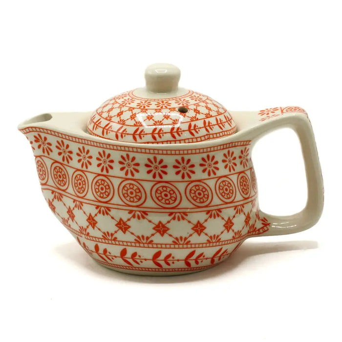 Small herbal teapot in cream ceramic with orange floral and geometric patterns for herbal tea cups and herbal teapot use