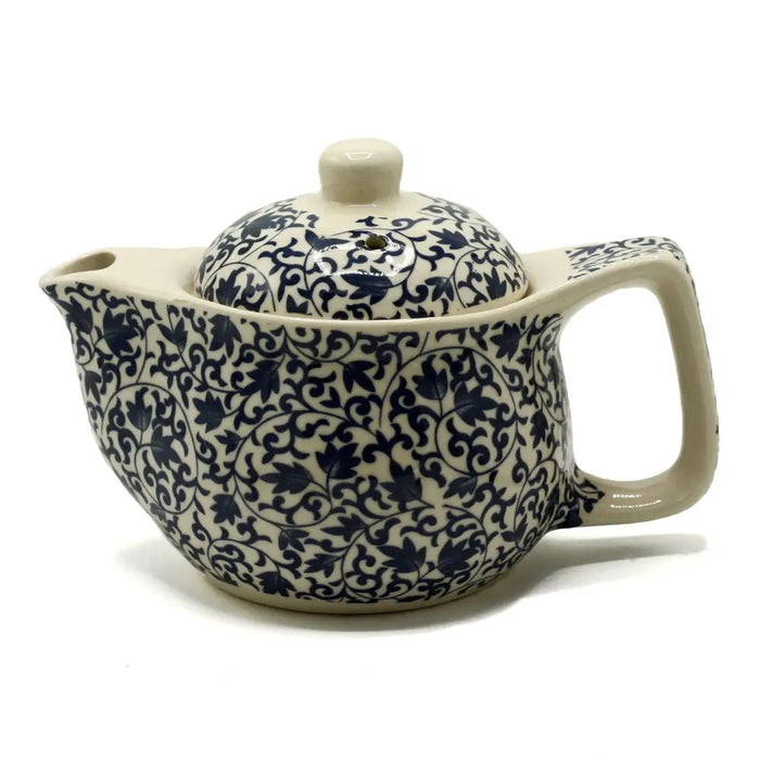 Cream-colored ceramic small herbal teapot with intricate navy blue floral and vine patterns for herbal tea cups