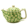 A small herbal teapot in light green ceramic with white and yellow daisy patterns for herbal tea cups use