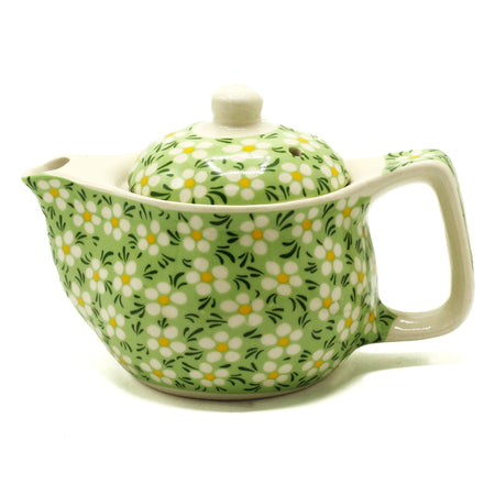 A small herbal teapot in light green ceramic with white and yellow daisy patterns for herbal tea cups use